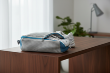 Sac SOLEVA Gris & Bleu avec une paire de chaussures techniques